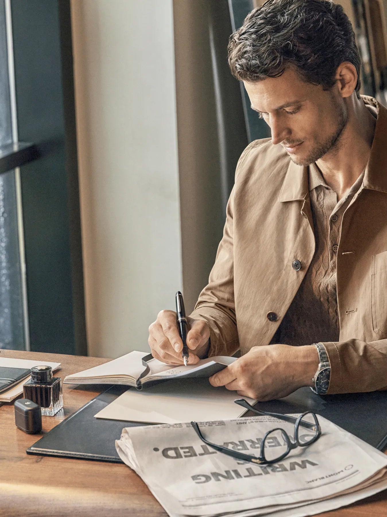 Experience craftsmanship with the Montblanc Meisterstück pen as a gentleman writes in his journal. Elevate your writing experience with Montblanc's luxury pens, combining style and precision for timeless expression.